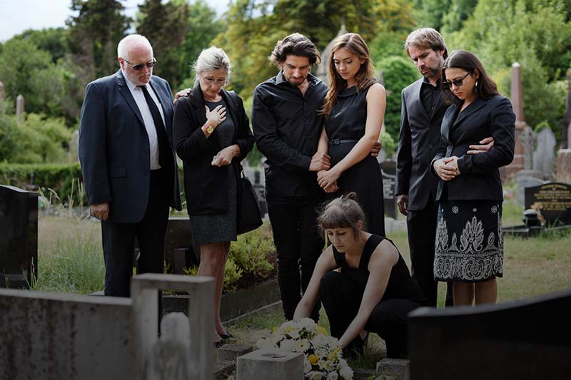 family visiting the gravestone of a family member who died wrongfully